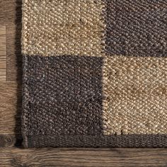 a brown and beige rug on top of a wooden floor