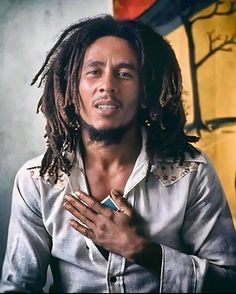 a man with dreadlocks holding his hands together