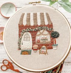 an embroidery kit with a brick building and flowers