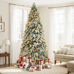 a decorated christmas tree in a living room with presents on the floor next to it