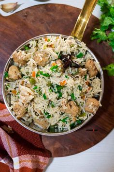 a bowl filled with rice and meat on top of a wooden cutting board next to parsley