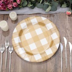 an empty plate on a table with silverware and flowers