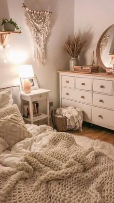 a bedroom with white furniture and blankets on the bed