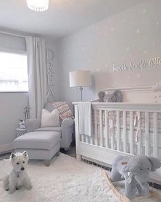 a baby's room with a crib, chair and stuffed animals