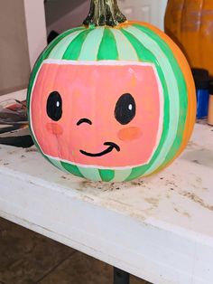 a painted pumpkin sitting on top of a table