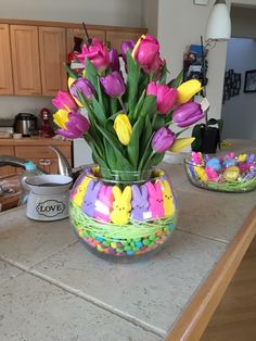 a vase filled with lots of flowers on top of a counter