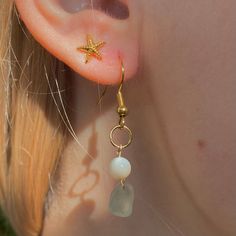 a close up of a person's ear with a starfish dangling from it