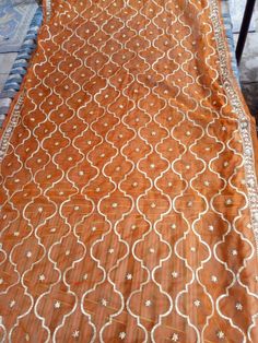 an orange and white table cloth on top of a wooden table