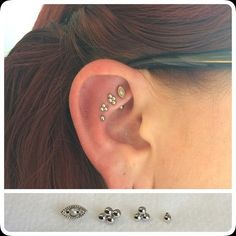 an ear with three different piercings on top of it and the bottom one is silver