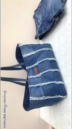 a pair of jeans sitting on top of a table next to a purse and wallet