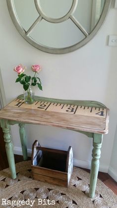 a wooden table with a ruler on it next to a flower pot and mirror in the corner