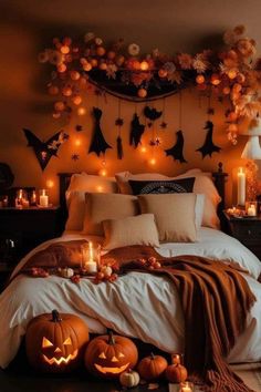 a bed with pumpkins, candles and decorations on the headboard in front of it