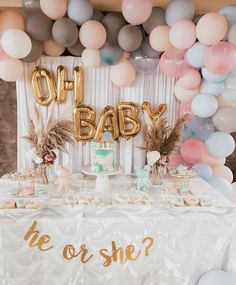 a baby shower table with balloons and cake