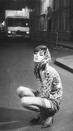 a woman sitting on the ground with her legs crossed and wearing leopard print clothing,