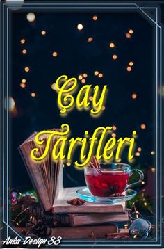 a cup of tea sitting on top of a table next to an open book with the words gay tarileri