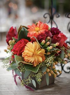 a vase filled with lots of flowers on top of a table