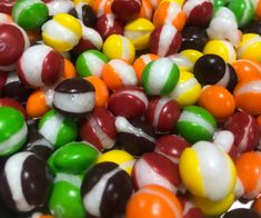 there are many different colored candy balls together