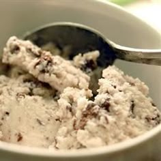 a bowl filled with ice cream sitting on top of a table next to a spoon