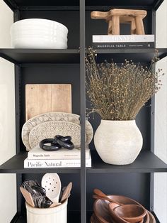 Mini Wooden pedestal in the casement hutch by Crate&Barrel stacked with books for height, Floral Platers on display with a touch of black marble in the form of round rings. Style Bookshelves, Hutch Styling, Desk Bar, Wooden Pedestal, Hutch Decor, Cabinet Style, Office Desks, Shelf Styling