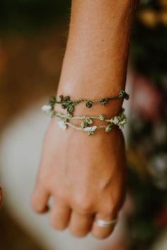 a close up of a person's hand wearing a bracelet with flowers on it