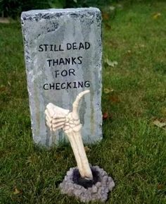 a tombstone with a hand holding a bone in it that says, still dead thanks for checking