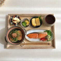 a wooden tray topped with different types of food