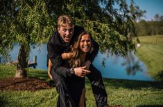 a man and woman are hugging under a tree