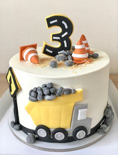 a three tiered cake with construction themed frosting and decorations on it's side