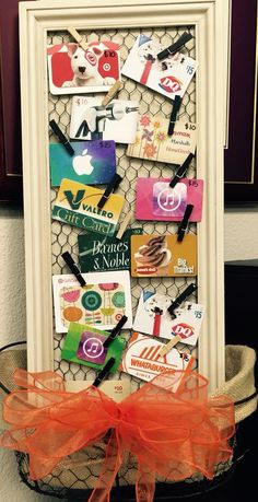 a white frame with orange ribbon on top of a basket filled with stickers and magnets