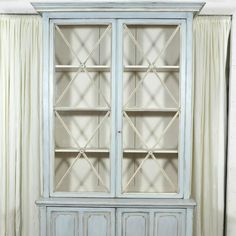 an old blue china cabinet with glass doors