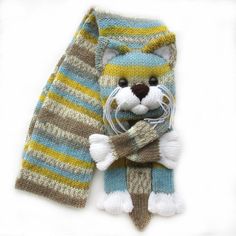 a knitted scarf with a stuffed animal on it's side and a striped scarf around the neck