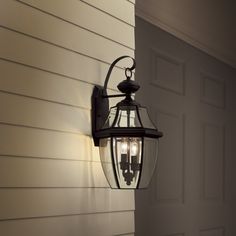 an outdoor light hanging on the side of a house