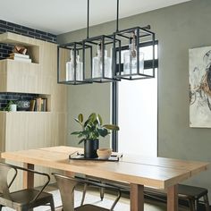 a dining room table with chairs and a potted plant sitting on top of it