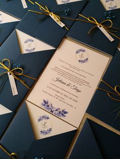 the wedding stationery is laid out on top of each other with ribbons and tags