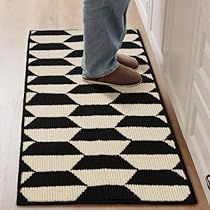 a person standing on a black and white rug in the middle of a door way