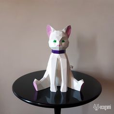 a white cat sitting on top of a black table