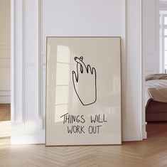 a white framed poster with the words things will work out on it in front of a bed