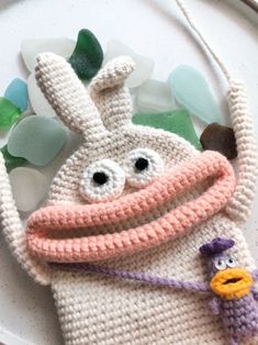 a crocheted bag with a cartoon character holding a purple object in it's mouth