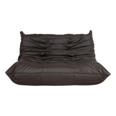 a brown leather futon sofa with pillows on it's back and the seat folded down