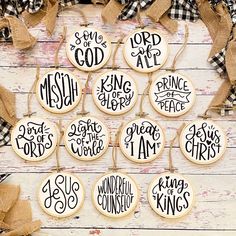 twelve decorated cookies with handwritten words are arranged on a white wooden surface and tied in burlap