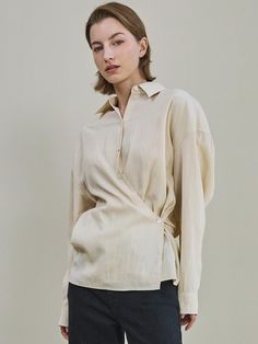 Soft and drapery, this relaxed fit shirt has classic open collars and button fastenings. It is accentuated with adjustable side button and strap detail for feminine fit.      - Intended for a loose fit  - Comfortable dropped shoulders  - Two-way styling with side button and strap detail  - Shirred detail at back  - Versatile styling and easy layering Beige Lapel Collar Top For Workwear, Versatile Cream Top For Workwear, Versatile Cream Top For Work, Chic Beige Spread Collar Top, Beige Spread Collar Shirt For Daywear, Beige Shirt With Spread Collar For Daywear, Beige Spread Collar Top For Work, Beige Shirt With Spread Collar, Beige Spread Collar Shirt