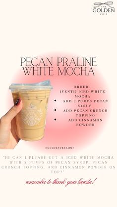 a person holding up a cup with the words pecan praline white mocha