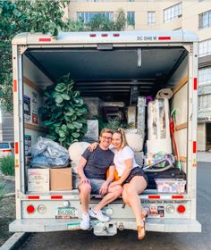 a man and woman sitting in the back of a moving truck