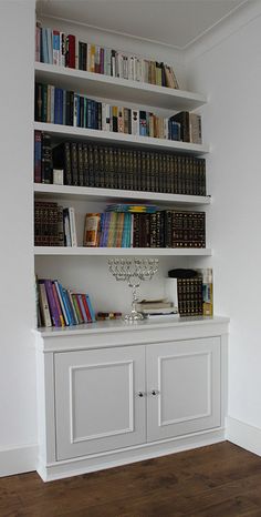 a bookshelf filled with lots of books in a room