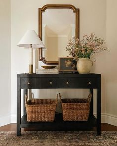 a black table with two baskets under a mirror