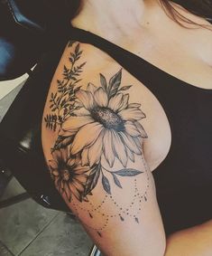 a woman's arm with flowers and leaves tattooed on the side of her body