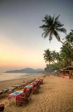 the beach is lined with tables and chairs