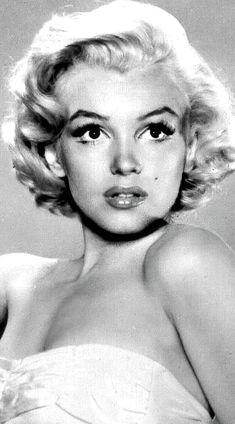 an old black and white photo of a woman in a strapless dress with short hair