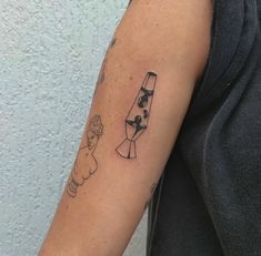 a person with a tattoo on their arm holding a wine glass and a small dog