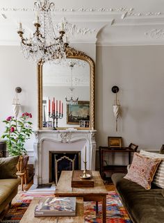 a living room filled with furniture and a large mirror on the wall over a fire place